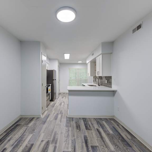 a room with a wooden floor and white walls.