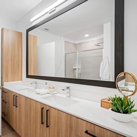 a bathroom with a large mirror and a sink at madison waterford lakes, orlando, fl
