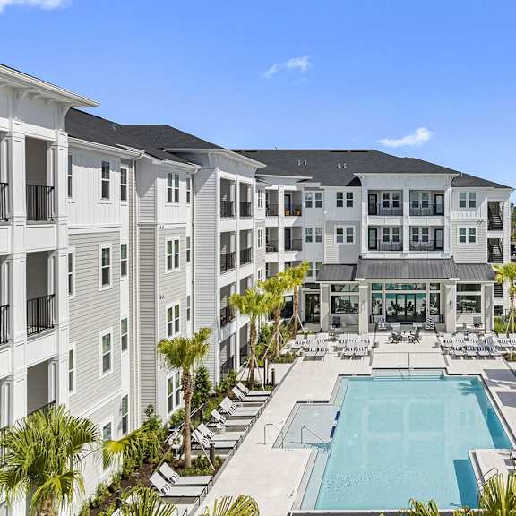 an apartment building with a pool in the middle at madison waterford lakes, orlando, fl, 32826