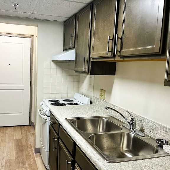 a kitchen with a white door and a stove top oven.