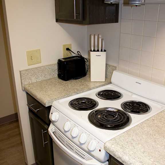 a white stove top oven with a black stove top and a black microwave above it.