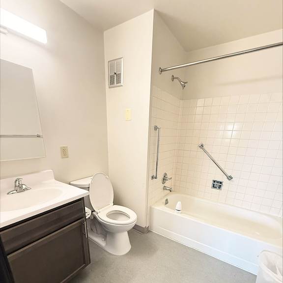 a white bathroom with a toilet, sink, and bathtub.
