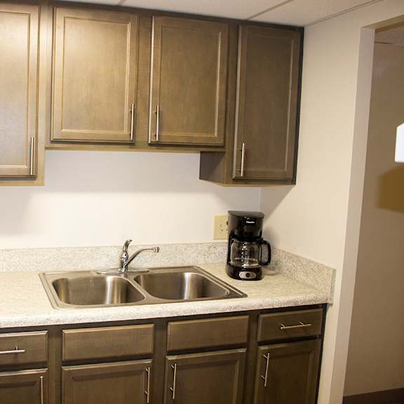 a kitchen with a white refrigerator and brown cabinets.