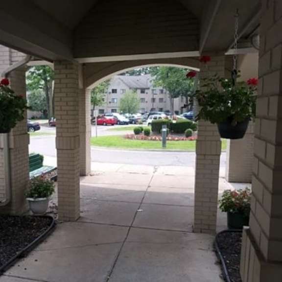 a view of a porch with a tree and a building in the background.