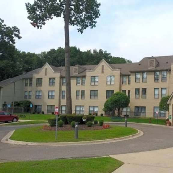 a large building with a green lawn in front.