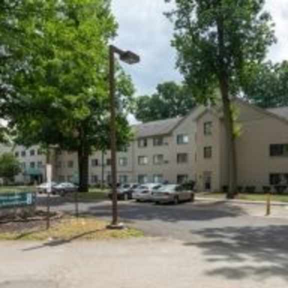 a parking lot in front of a building with trees.