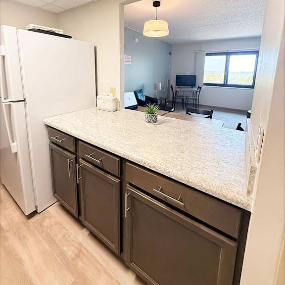 a kitchen with a white fridge and brown cabinets.