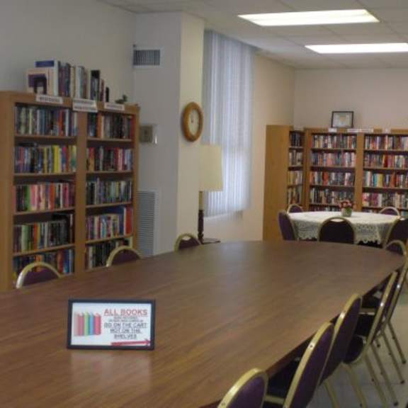 a library with a sign that says "all books belong to everyone.".