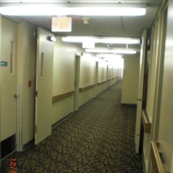a long hallway with doors on both sides and a carpeted floor.