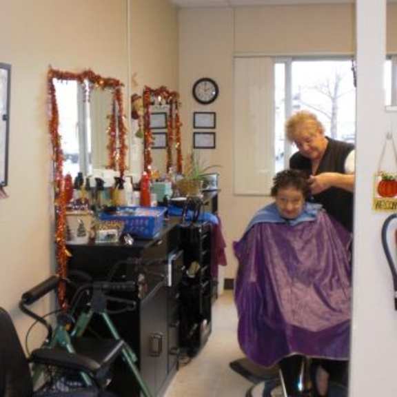 a hairdresser is cutting a customer's hair in a salon.