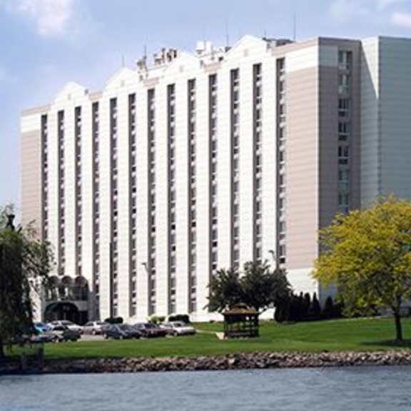 a large white building with a lot of windows sits next to a body of water.
