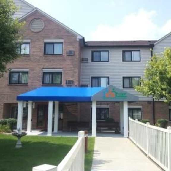 a building with a blue awning and a white picket fence in front.