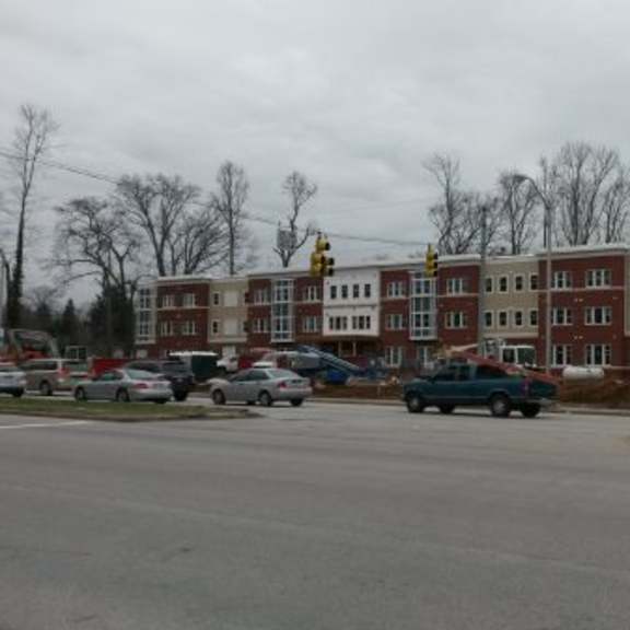a parking lot with cars and a building in the background.