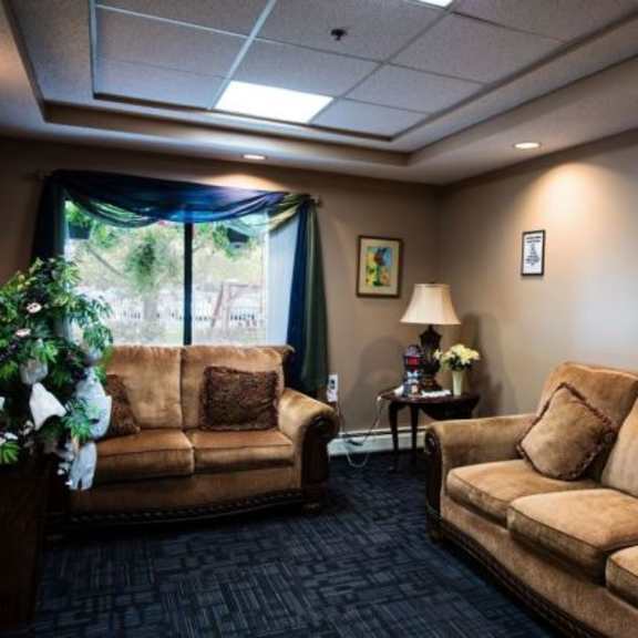 a living room with two couches and a small table with a lamp.