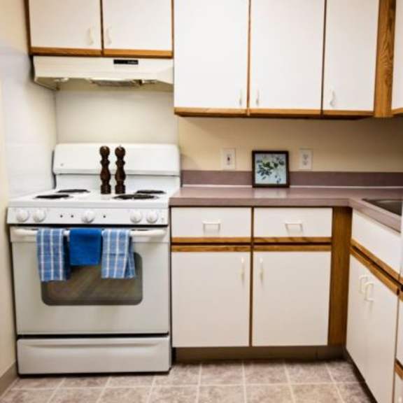 a kitchen with a white stove and white refrigerator.