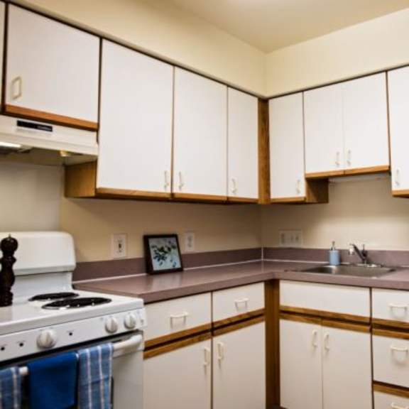a kitchen with white cabinets and a white refrigerator.