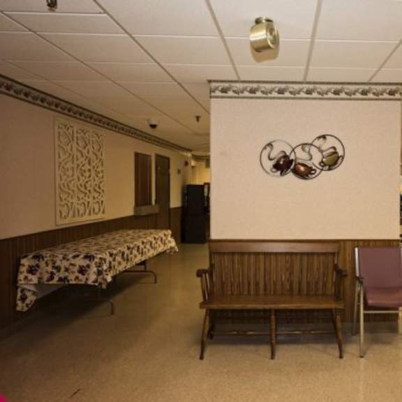 a room with a mural of a bird on the wall and chairs and tables arranged for a meeting.