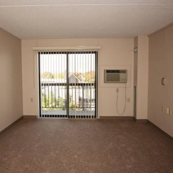 a room with a carpeted floor and a sliding glass door leading outside.