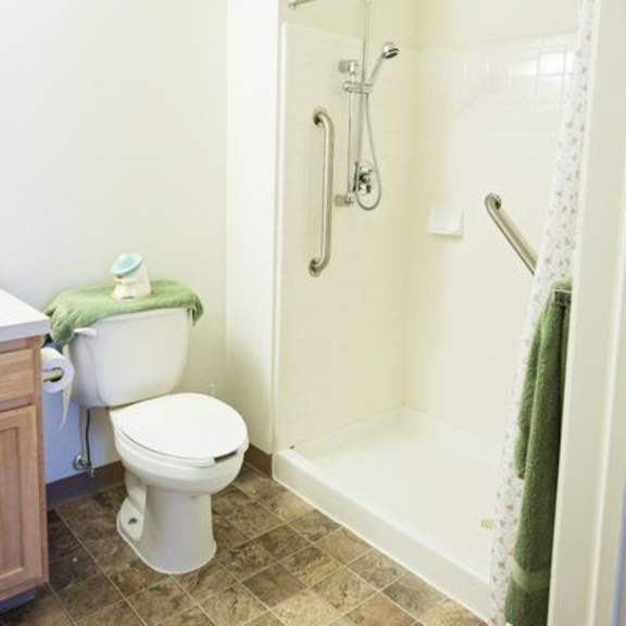 a white toilet with a green towel on top of it.