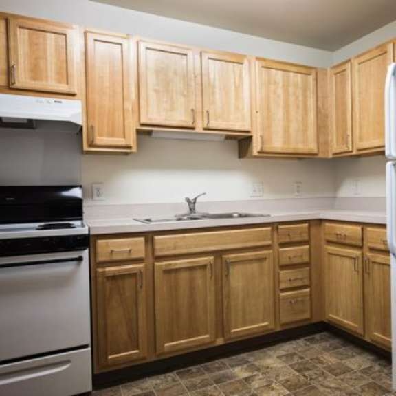 a kitchen with wooden cabinets and a white refrigerator.