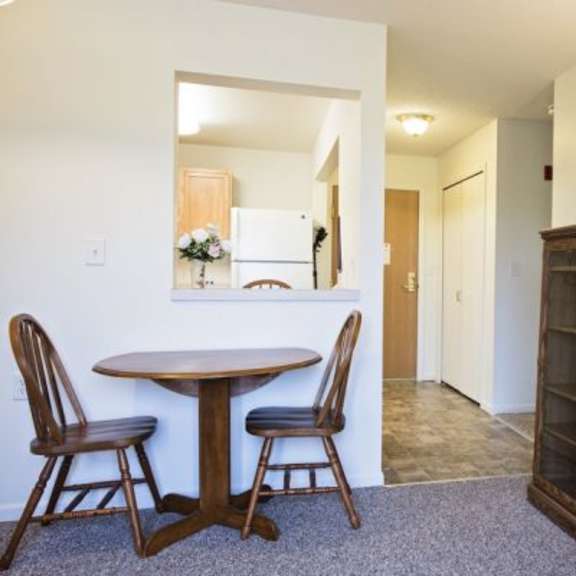 a dining room with a round table and chairs.