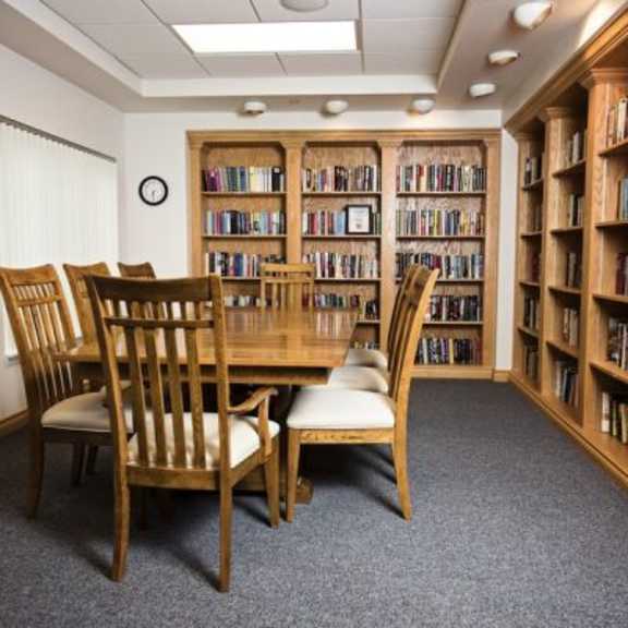 a room with a table and chairs and bookshelves filled with books.