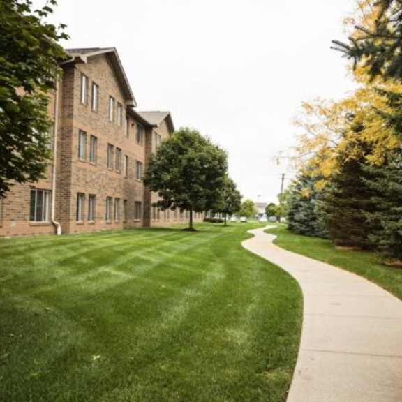 a long building with a green lawn in front of it.