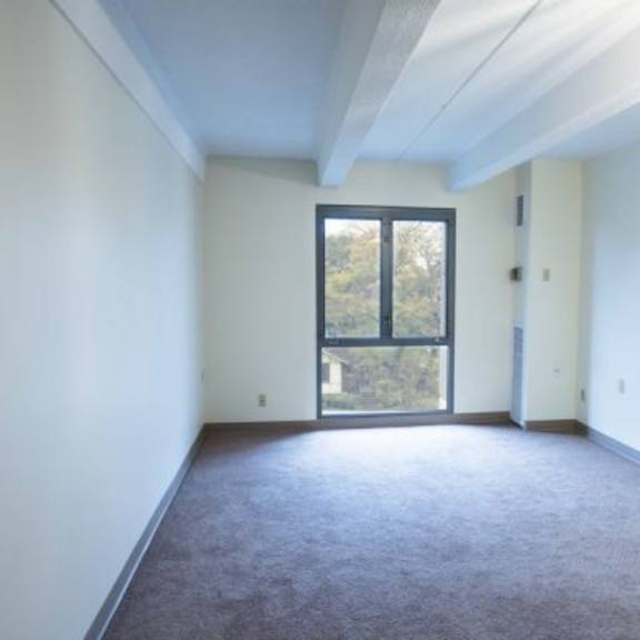a room with a window and carpeted floor.