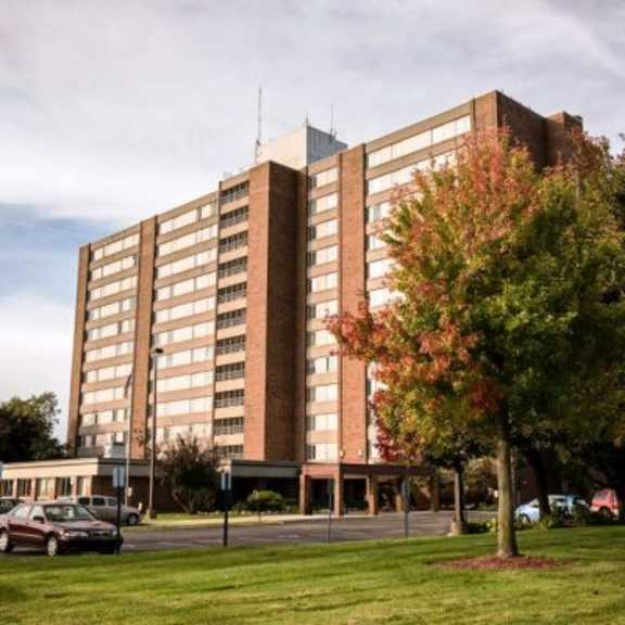 a large brick building with a parking lot in front.