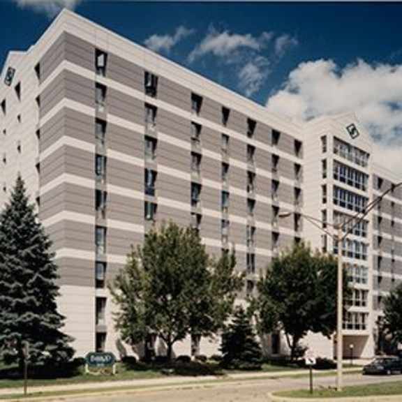 a large white building with a green sign in front.