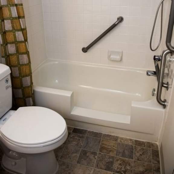 a white toilet sits next to a bathtub in a bathroom.