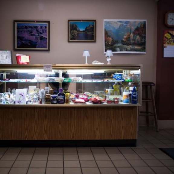 a display case filled with an assortment of items sits in a room with a brown wall.