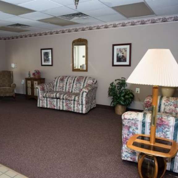 a living room with a couch, chair, and lamp.