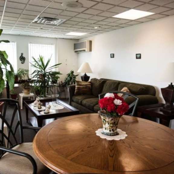 a living room with a brown table and a vase of flowers on it.