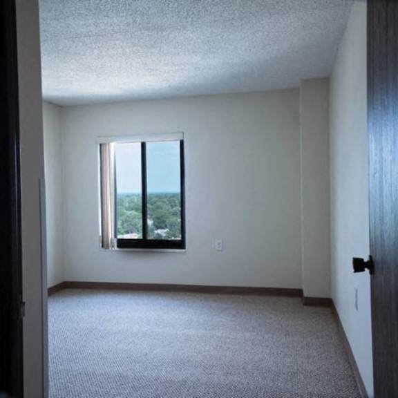 a room with a window and carpeted floor.