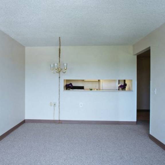 a room with a chandelier and a window with blinds.