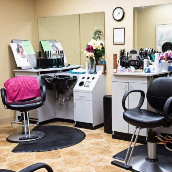 a hair salon with two chairs and a mirror.