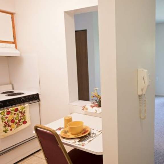 a small kitchen with a table and chairs.