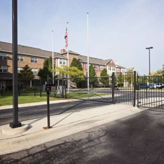 a black gate blocks the entrance to a parking lot.