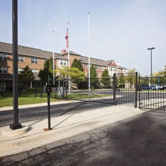 a black gate blocks the entrance to a parking lot.