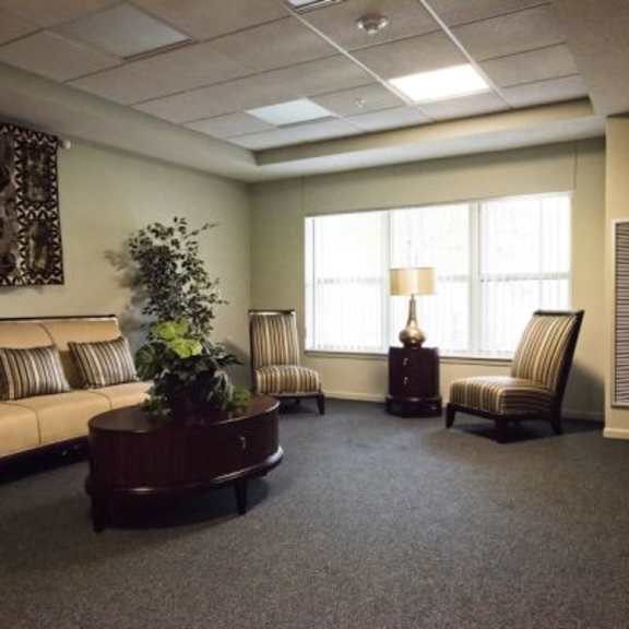 a waiting room with a couch, two chairs, and a coffee table.