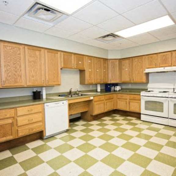 a kitchen with wooden cabinets and a checkered floor.