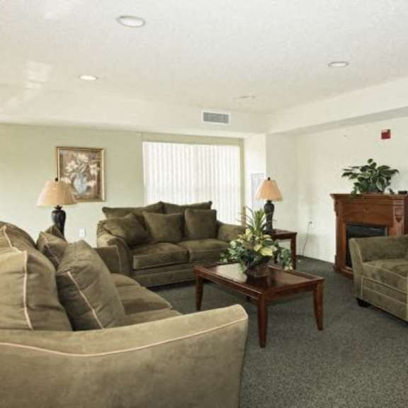 a living room with a brown couch, a coffee table, and a fireplace.