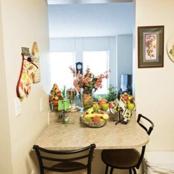 a kitchen with a table and chairs and a fruit bowl on the table.