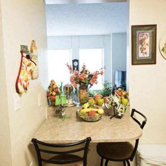 a kitchen with a table and chairs and a fruit bowl on the table.