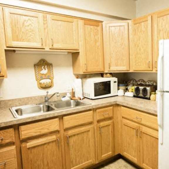 a kitchen with wooden cabinets and a white refrigerator.