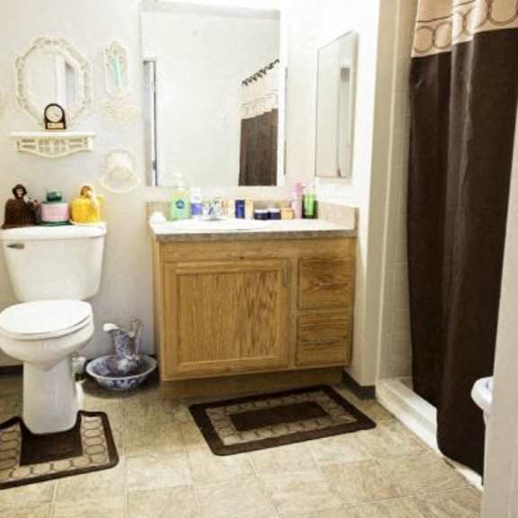 a bathroom with a toilet, sink, and mirror.