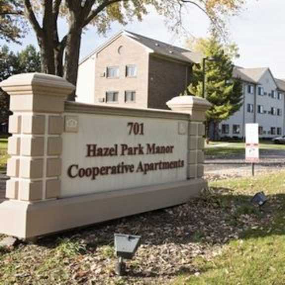 a sign for hazel park manor cooperative apartments is in front of a building.