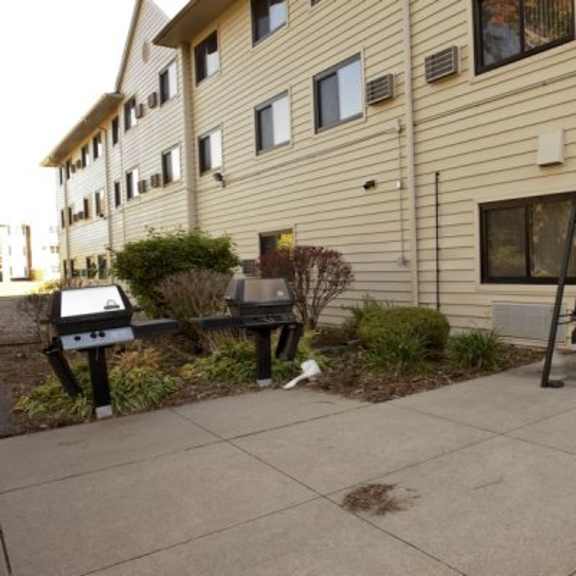 a building with a bench and a small tree in front of it.