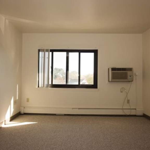a room with a window and a carpeted floor.